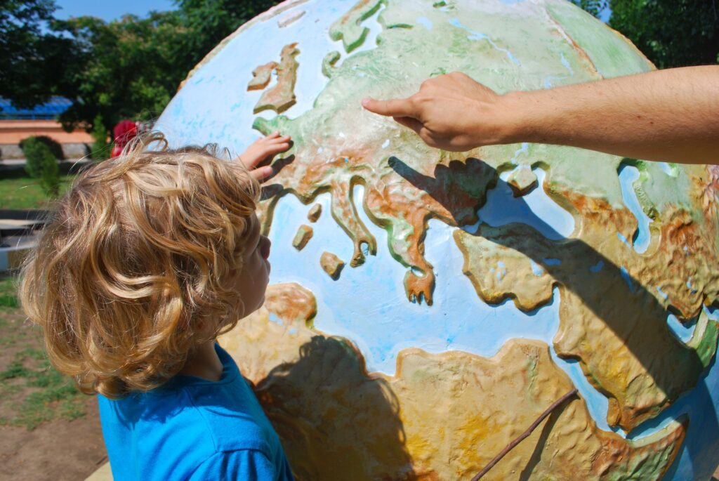 子どもが世界地図を指さしている